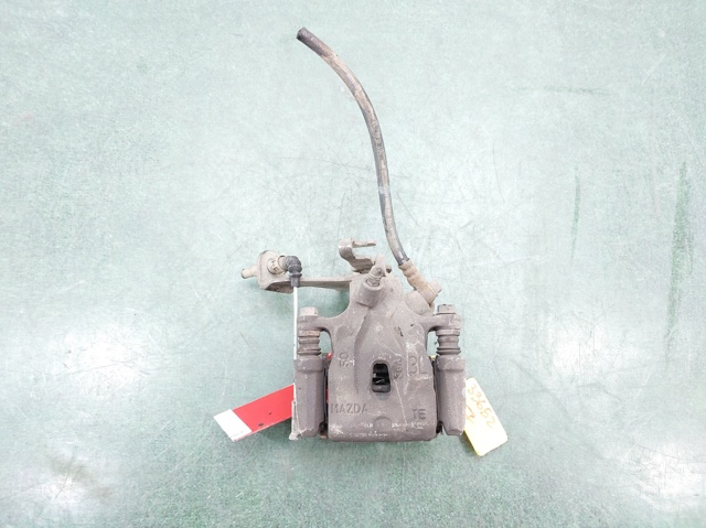 Zacisk hamulcowy tylny lewy K0Y12699ZA MAZDA